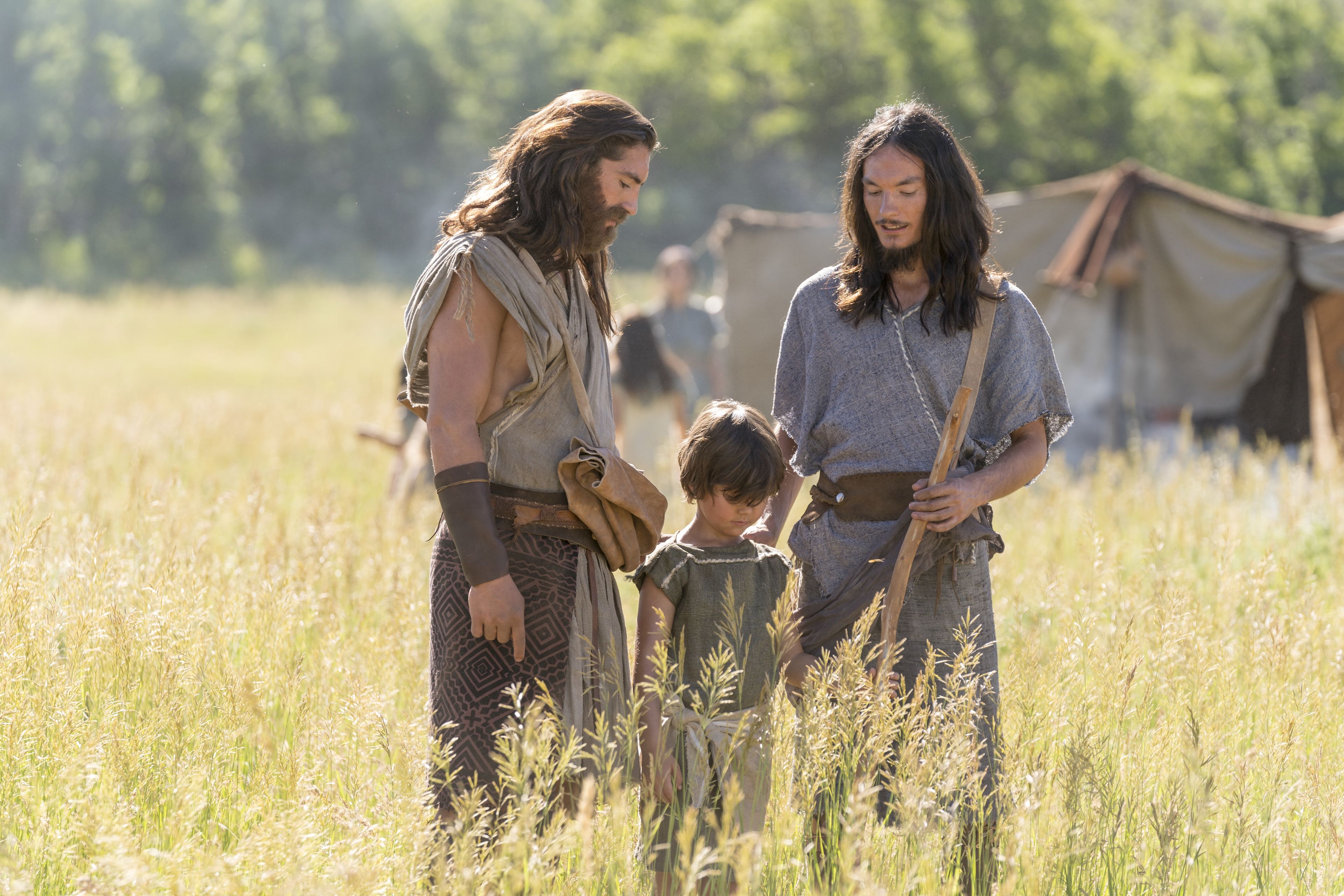 Nephi, Sam, and a child work together in a field.