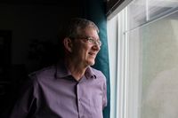 Um homem olha pela janela e pensa em suas bênçãos