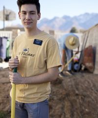 A missionary models appropriate clothing for working outside and giving service. He is wearing a t-shirt and gym shorts.