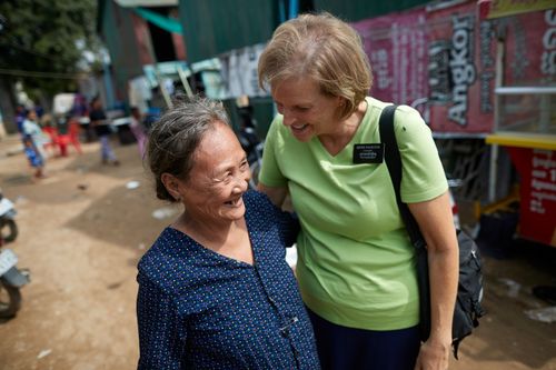 A senior sister missionary walks with an older woman in the streets of Phnom Penh, Cambodia.