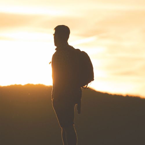 Un hombre contemplando una puesta de sol
