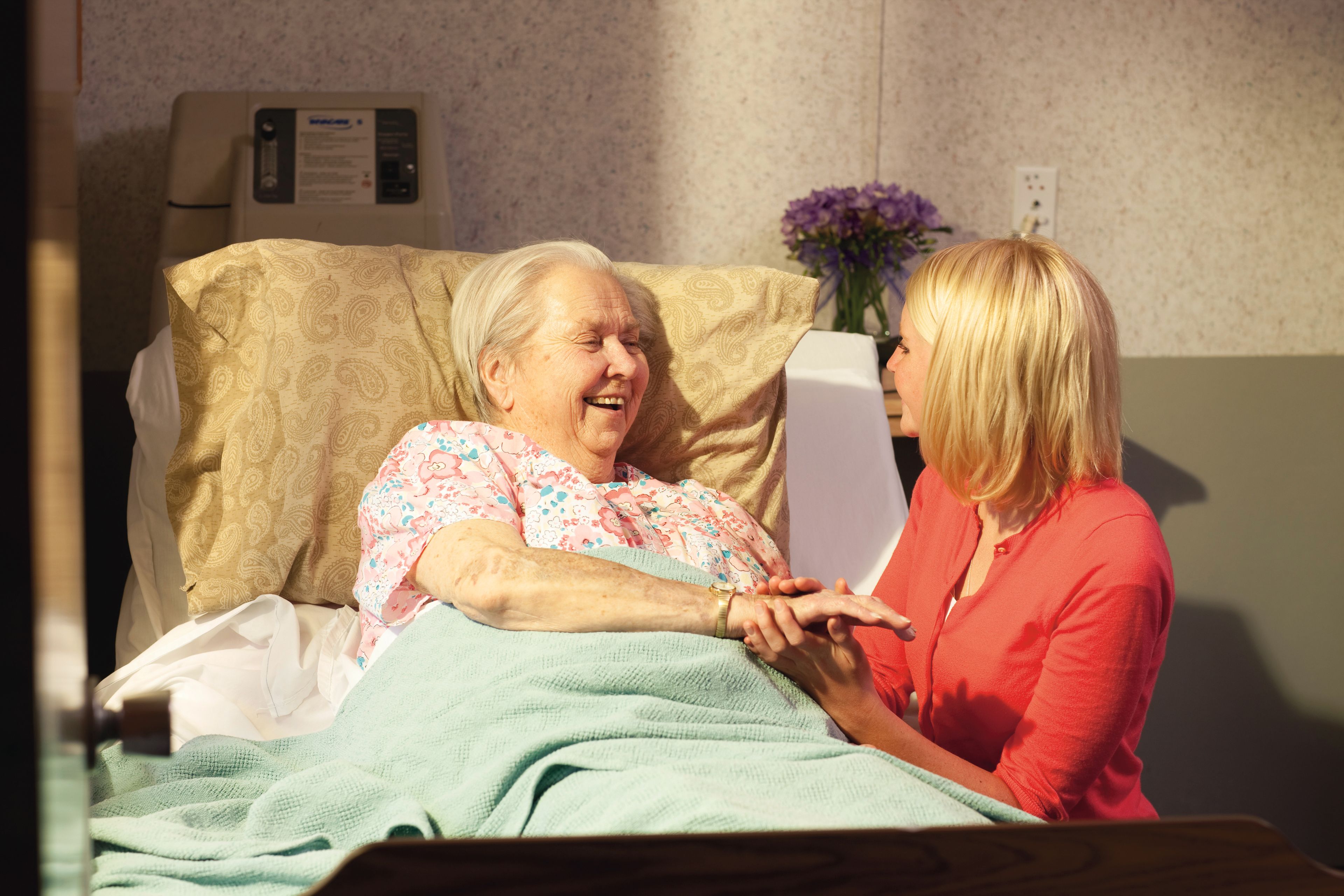 A young woman visits an elderly woman in the hospital.