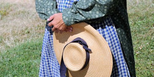 pioneer woman holding straw hat