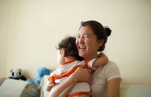 a mother holding her child and laughing