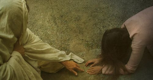 Jesus med en kvinna som fallit till marken
