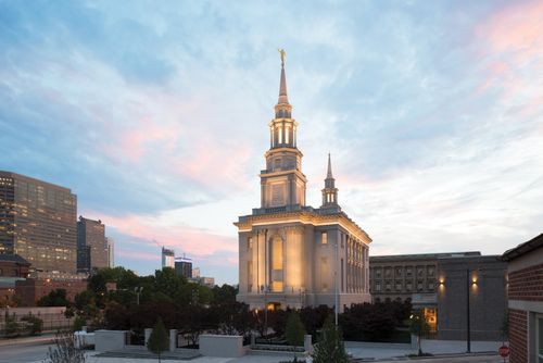 An exterior view of the Philadelphia Pennsylvania Temple with its lights on during a sunset.