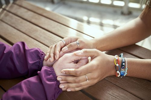 dos personas se toman de la mano sobre una mesa