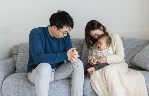 young parents praying with their young child