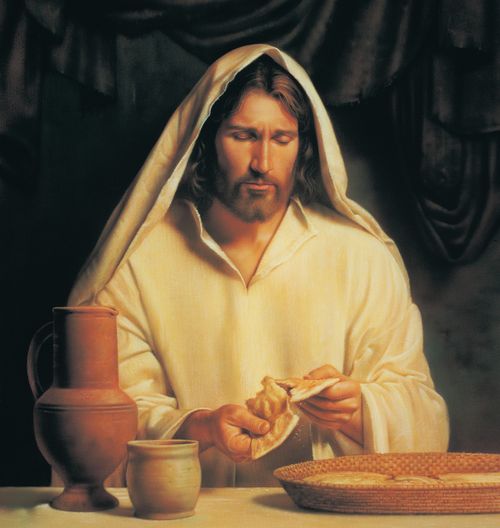 A painting of Jesus Christ wearing a white robe and pulling a small loaf of bread to pieces.