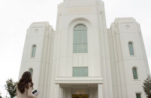 a young woman looking at the temple and thinking about her covenants