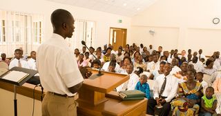 млад мъж държи реч на събрание за причастие