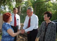 President Dieter F. Uchtdorf and Sister Harriet Uchtdorf meet with members during their visit to a dacha in Samara, Russia.