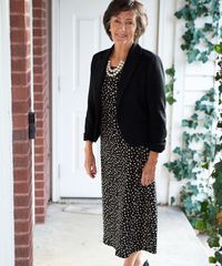 A senior missionary models appropriate dress and attire. She is wearing an approved cardigan, dress, and shoes.