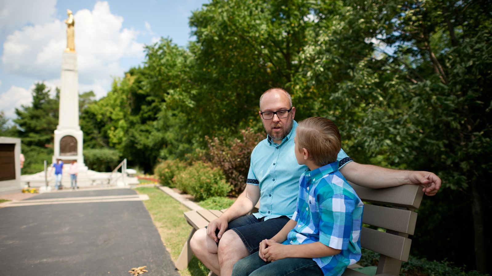 Various family members sit on a bench on the path leading to the Hill Cumorah in Manchester, New York.