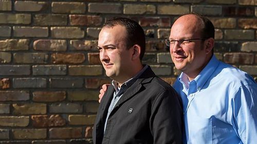 двое мужчин стоят у стены