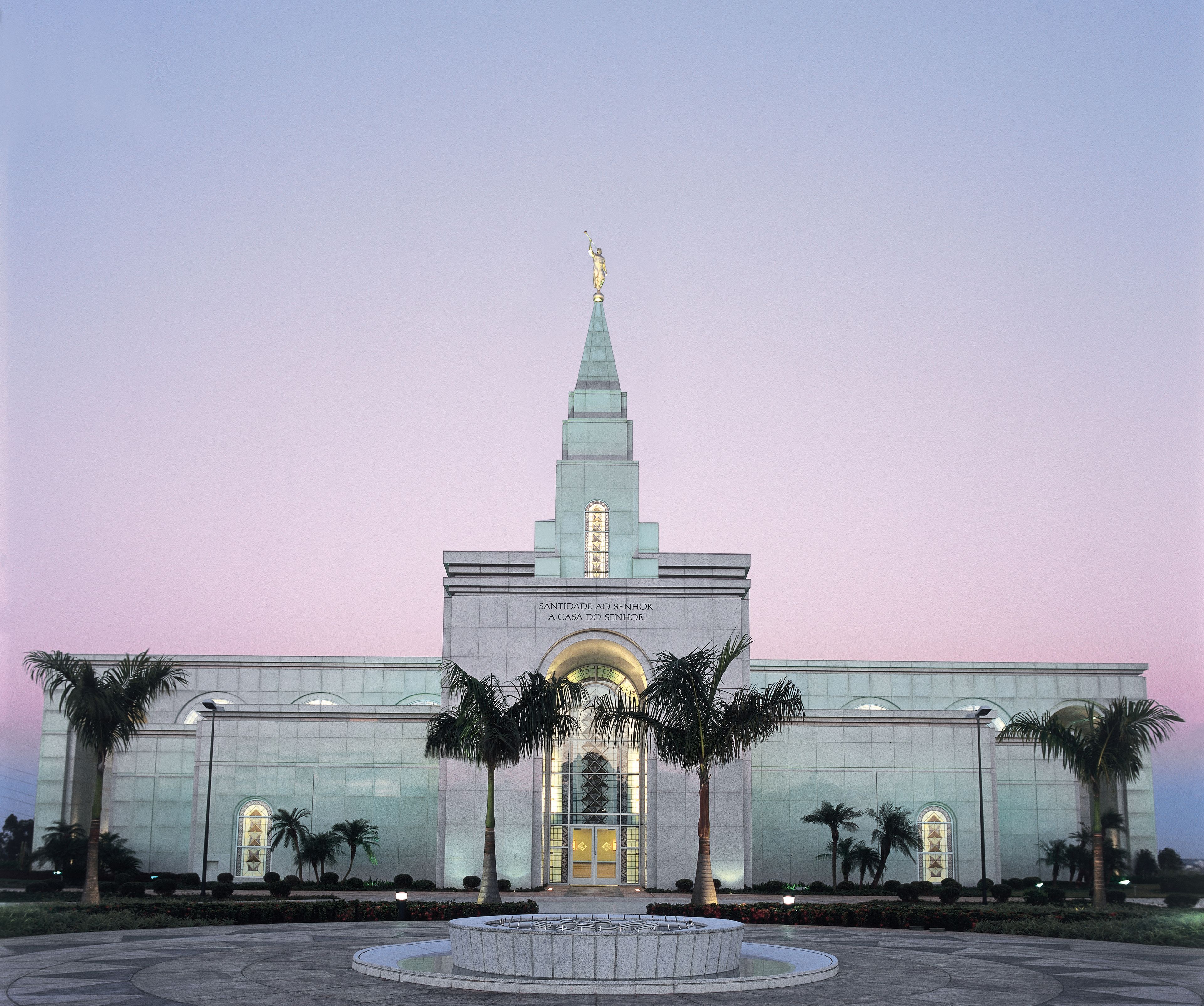 An exterior view of the Campinas Brazil Temple and its main entrance at dusk.
