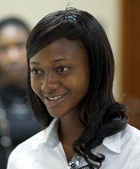 A sister missionary smiles as she listens to somebody talk to her while attending the MTC in Ghana.