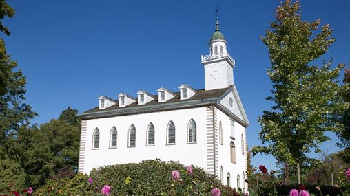 Exterior view of the Kirtland Temple with landscaping.