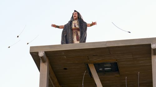 Samuel the Lamanite stands on top of a wall and preaches to the people. Archers shoot at him. 