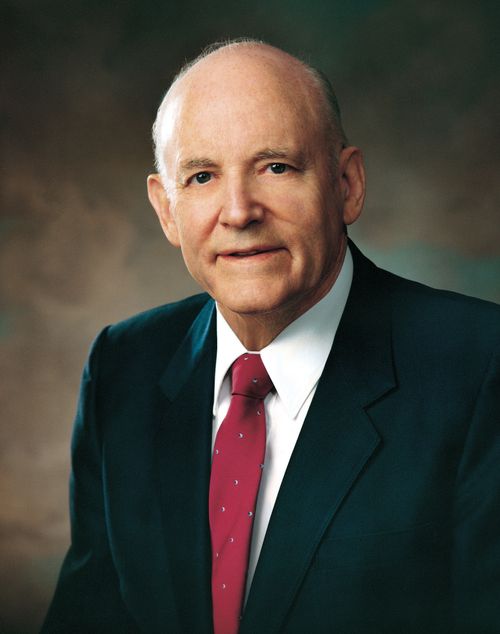 A portrait of President Howard W. Hunter in a dark blue suit, white shirt, and red tie.