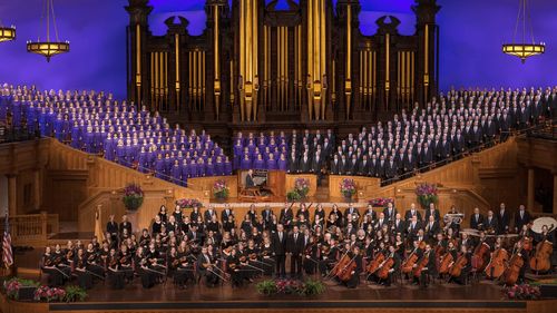 The 2018 portrait of the Tabernacle Choir and the Orchestra at Temple Square. The performers are posing in front of the organ pipes of the Salt Lake Tabernacle.