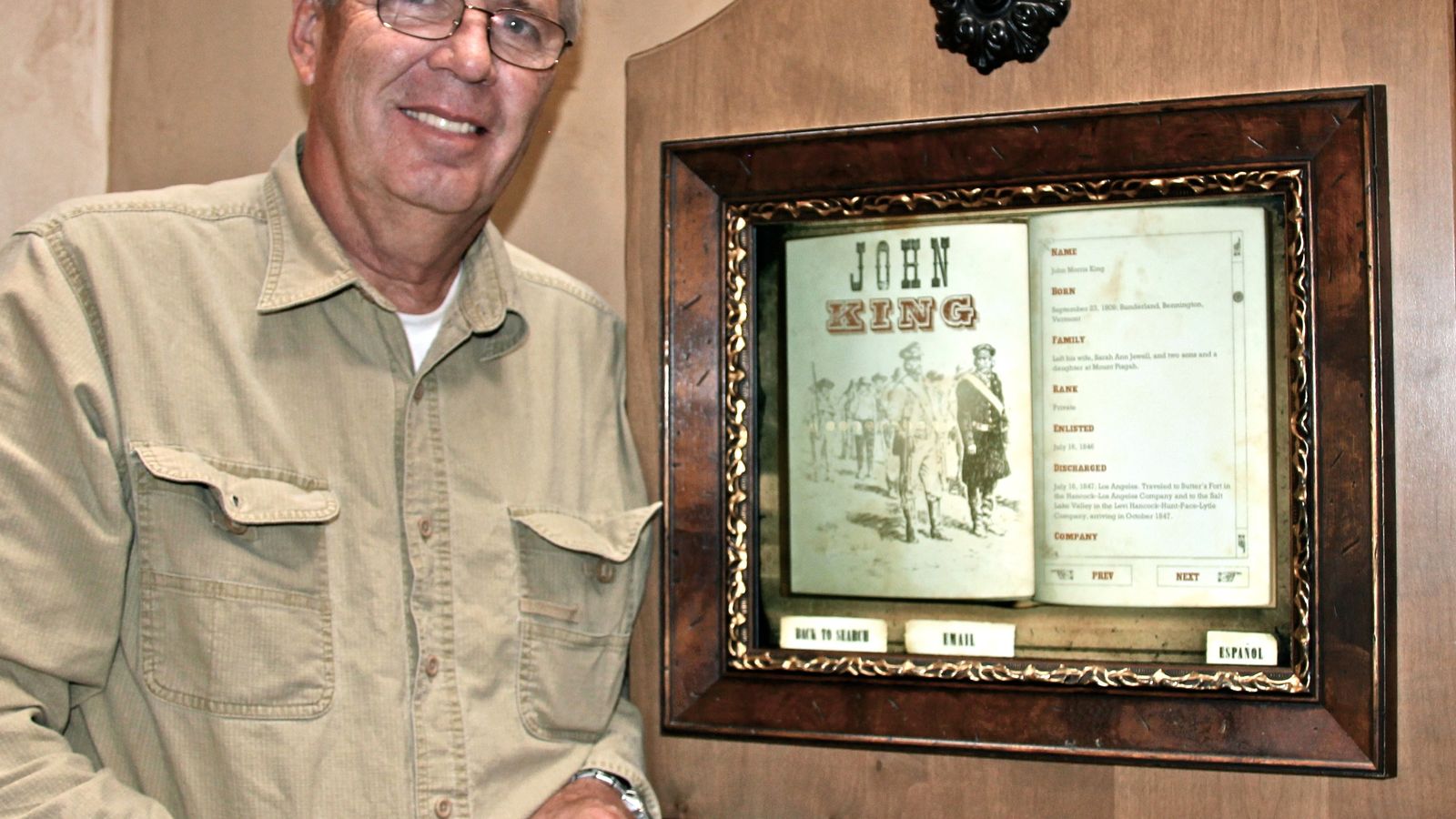 Man standing by framed image on the wall