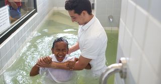 un niño contento siendo bautizado