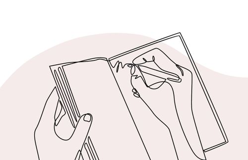 hand som håller i en penna och skriver i en öppen bok