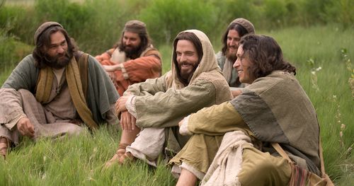 Jesus teaches disciples while seated on hillside.