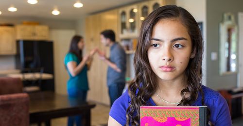 A young teen girl stands by as her parents are fighting.