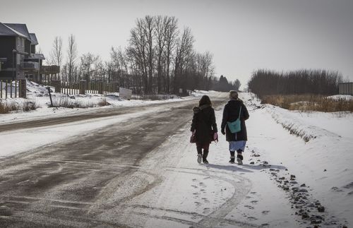 sister missionaries walking down a snowy road