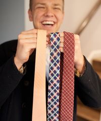 A missionary models appropriate dress and attire. He shows off some of his approved ties.