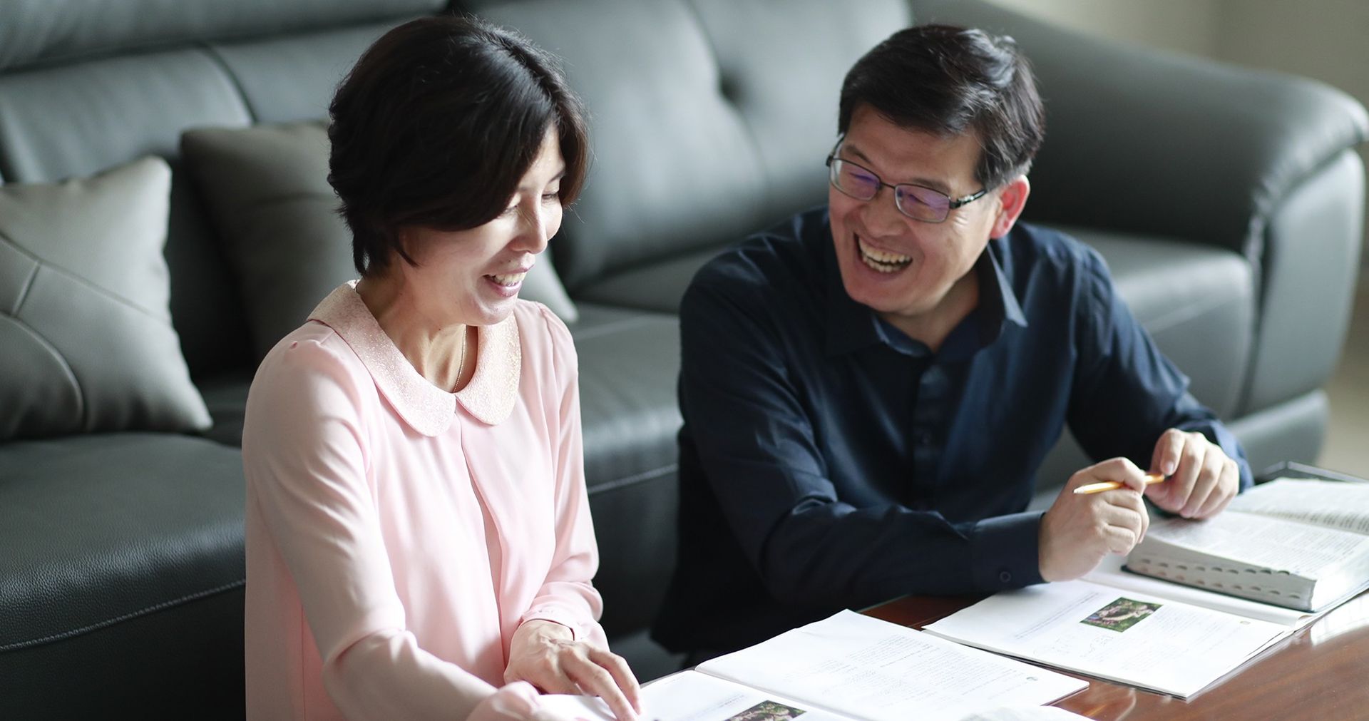 A Korean couple read, study, and discuss the scriptures together in their home.