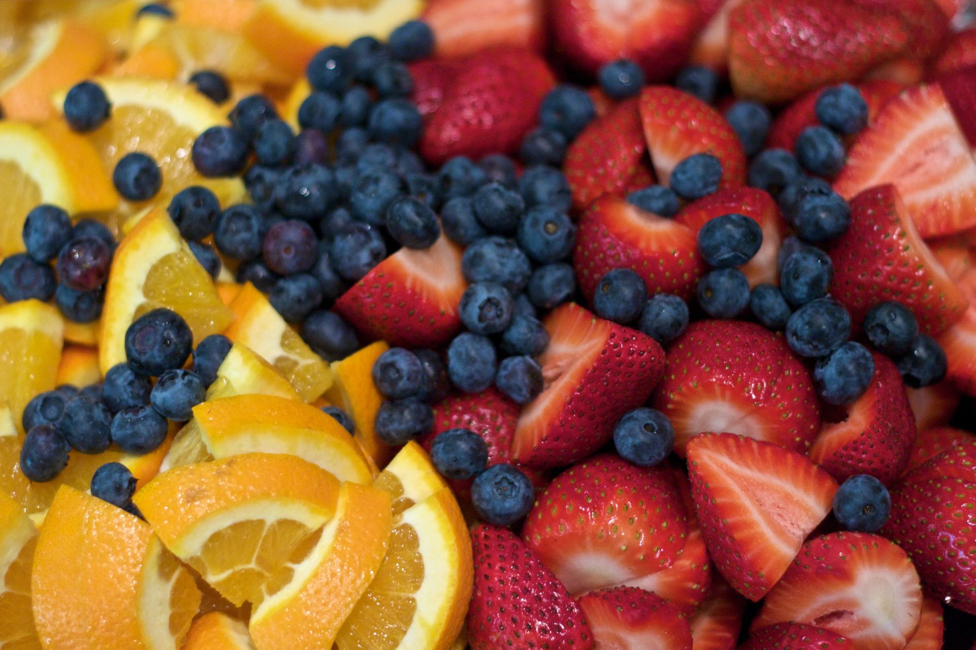 A combination of orange slices, blueberries, and strawberries.