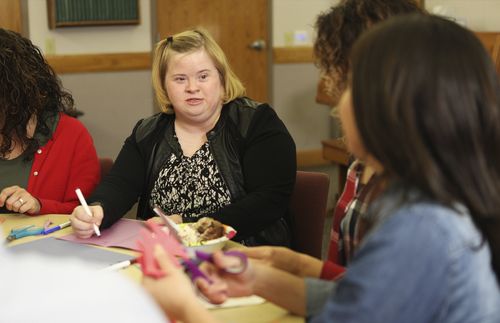a woman with special needs sits at a table