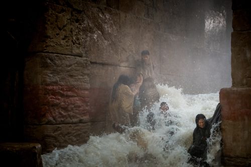 A flash flood sweeps people away, while a blind girl is rescued by her father
