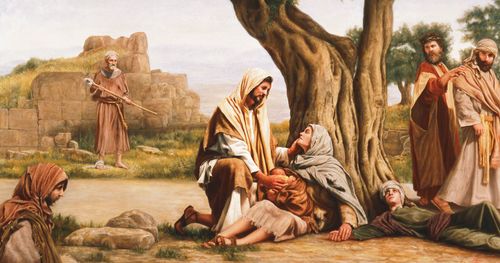 Jesus Christ portrayed kneeling next to a sick woman. The woman is holding a baby and leaning against a tree. Christ is healing the woman of sickness. Other people are lying or walking near the tree as they watch or wait to be healed.