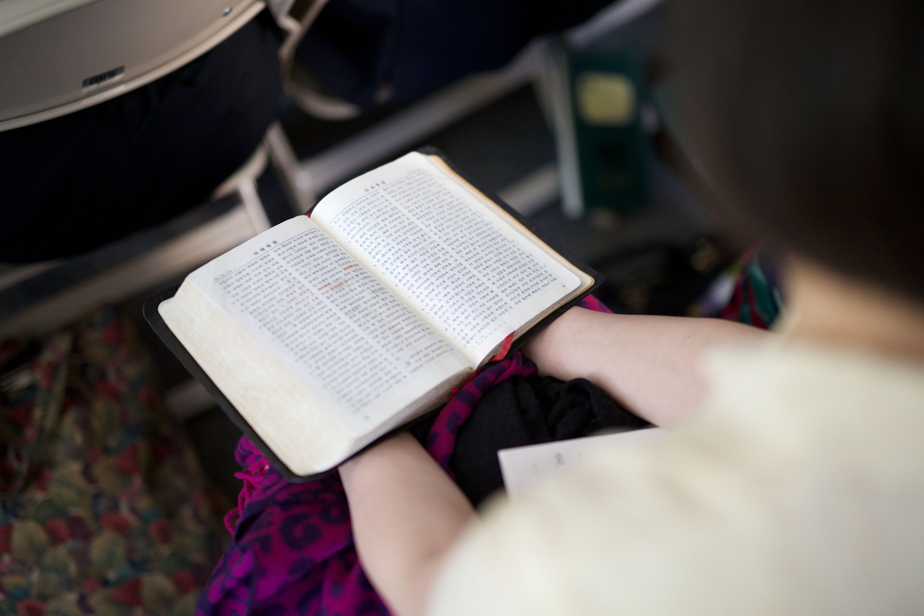 A young woman holds the scriptures during class.