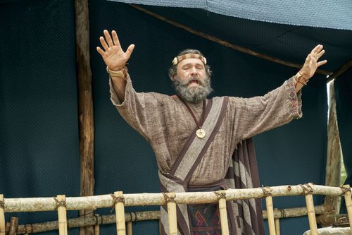 King Benjamin stands on a tower speaking to the Nephites in the Land of Zarahemla.