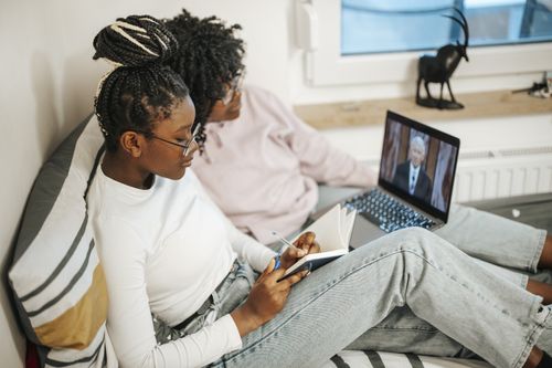 two women watching general conference on a laptop