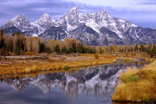 The Teton Mountains topped with snow, reflected in a river in Wyoming.