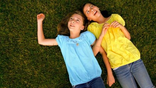 deux filles allongées sur le sol en train d’observer le ciel