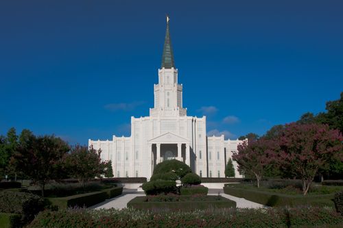 The front of the Houston Texas Temple, with trees and bushes on the grounds.