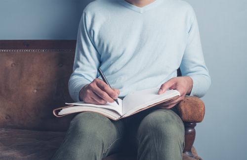 Ein Mann schreibt in ein Notizbuch