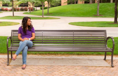 Eine Frau sitzt allein auf einer Bank