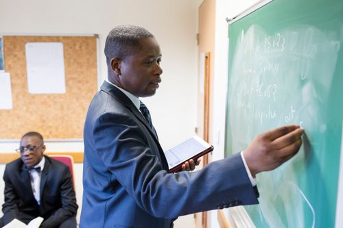 Man teaches at a chalkboard