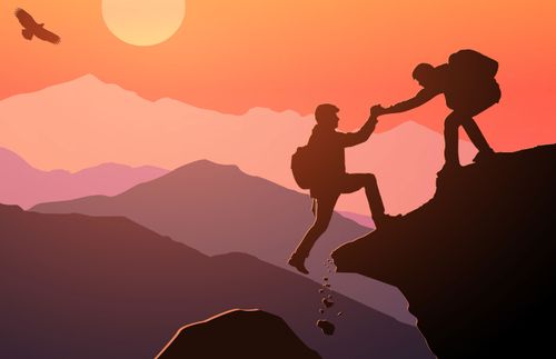 Una persona ayudando a otra a escalar una montaña