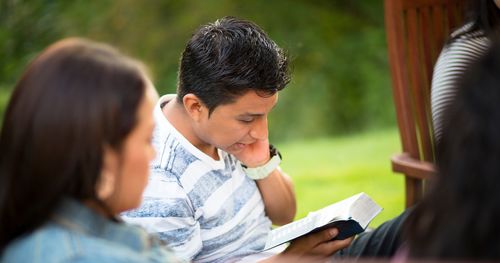 Junge Erwachsene schauen in die heiligen Schriften