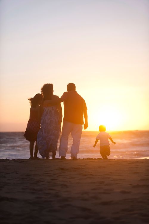 family watching sunset by ocean