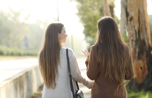 two women talking together in a park